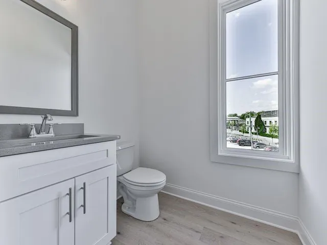 a bathroom with a granite countertop toilet sink and mirror