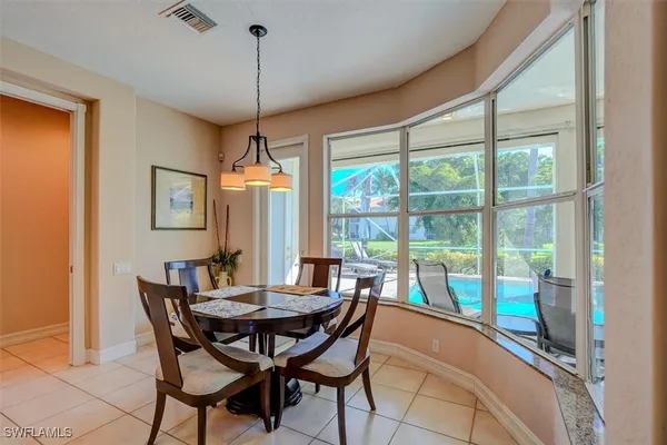 a dining room with furniture a chandelier and wooden floor