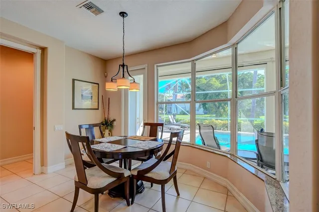 a dining room with furniture a chandelier and wooden floor