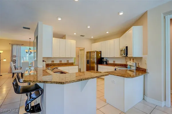 a kitchen with a sink a stove and chairs