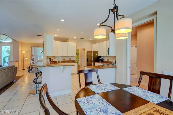 a kitchen with a table chairs refrigerator and microwave