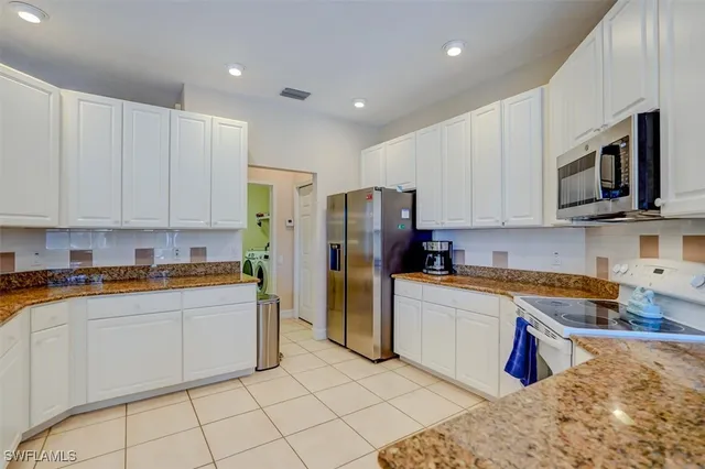 a kitchen with stainless steel appliances granite countertop a refrigerator sink and microwave