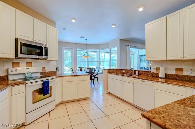a kitchen with appliances a sink and cabinets