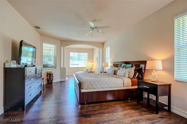 a bedroom with bed and wooden floor