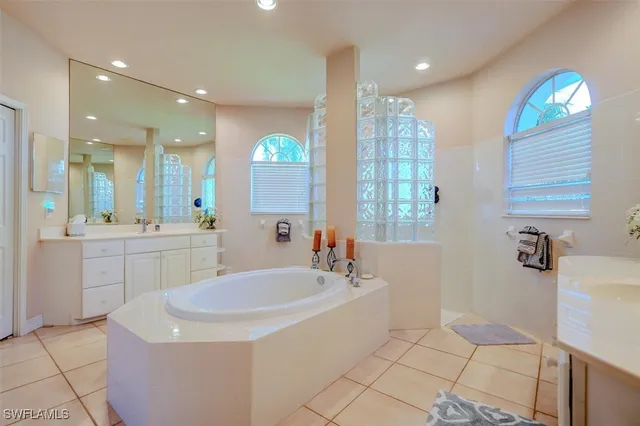 a bathroom with a sink a tub and a mirror