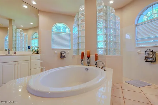 a bathroom with a tub sink and mirror
