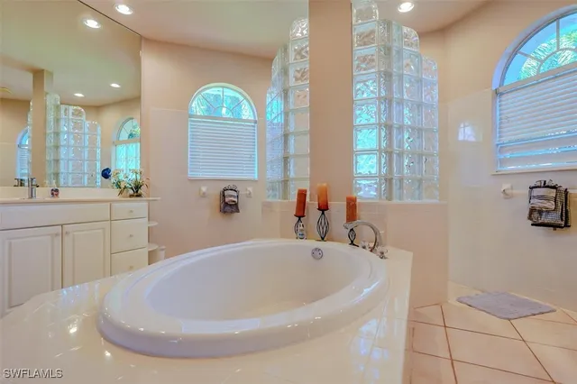 a bathroom with a tub sink and mirror