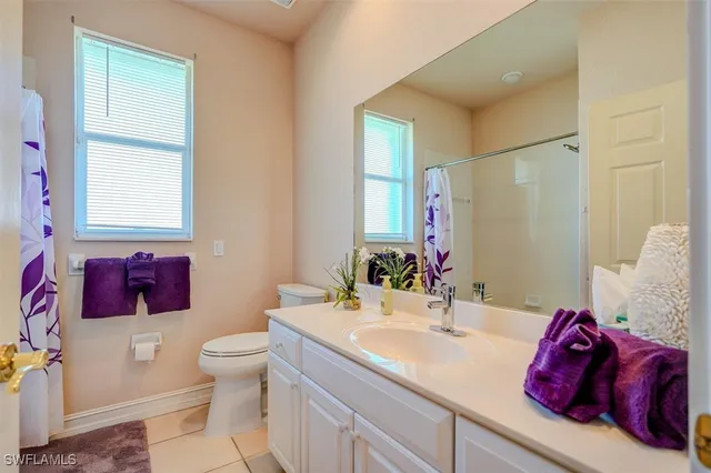 a bathroom with a granite countertop sink mirror vanity and toilet