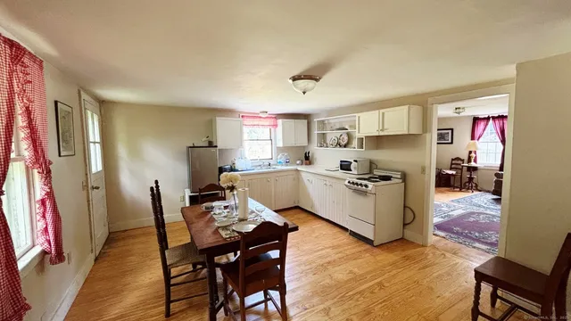 a kitchen with stainless steel appliances a table and chairs in it