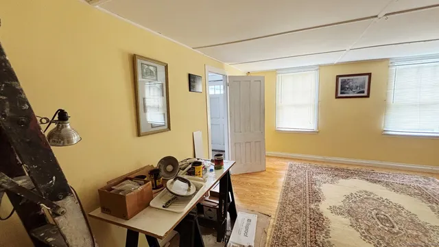 a view of a workspace with furniture and a window