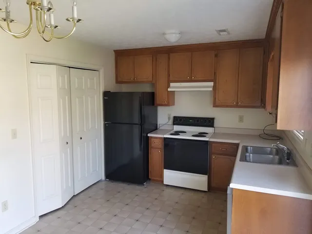 a kitchen with stainless steel appliances granite countertop a refrigerator a sink and a stove