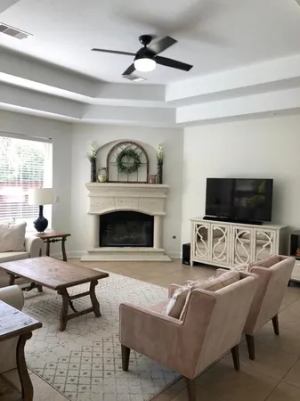 a living room with furniture a flat screen tv and a fireplace