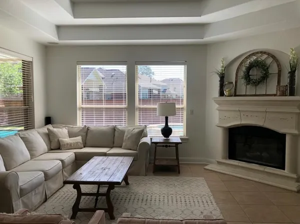 a living room with furniture a large window and a fireplace
