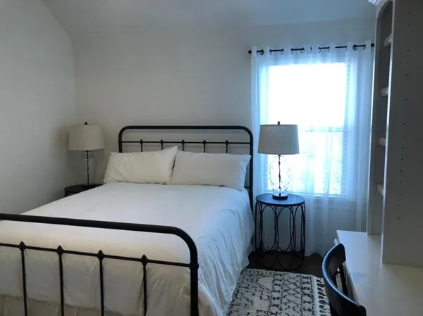 a bedroom with a bed and a window