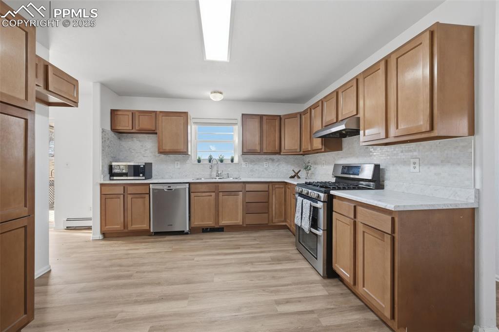 747 D Street Penrose, CO 81240 - Photo 12 of 36 a kitchen with stainless steel appliances granite countertop a stove a sink dishwasher and a refrigerator