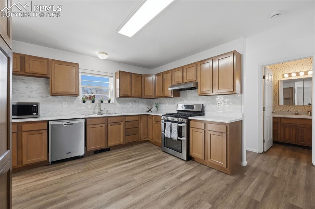 747 D Street Penrose, CO 81240 - Photo 13 of 36 a kitchen with stainless steel appliances granite countertop a sink cabinets and wooden floor