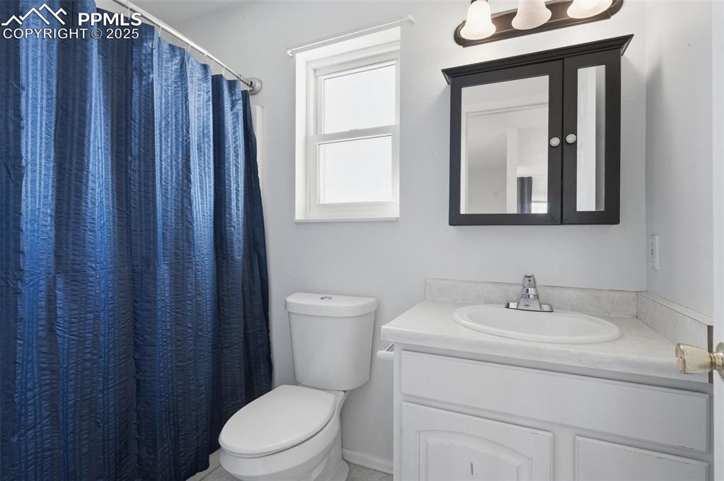 747 D Street Penrose, CO 81240 - Photo 24 of 36 a bathroom with a toilet a sink and mirror