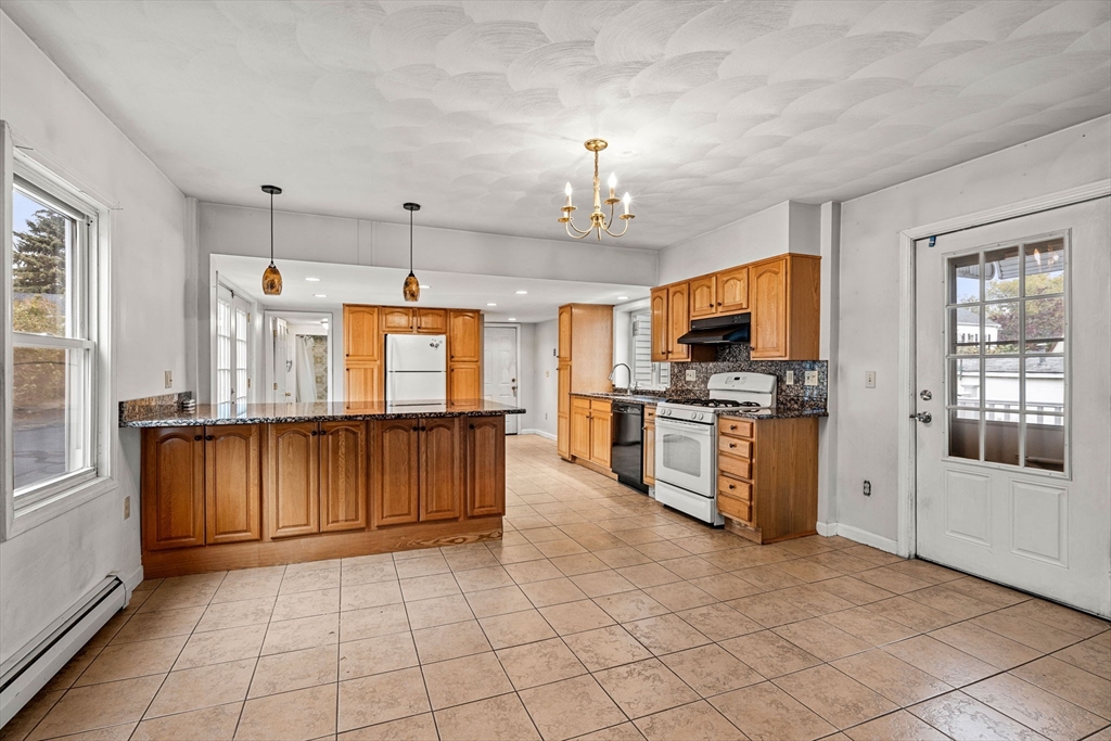 26 Elm Peabody, MA 01960 - Photo 12 of 41 a kitchen with stainless steel appliances kitchen island granite countertop a refrigerator oven a sink dishwasher and white cabinets with wooden floor
