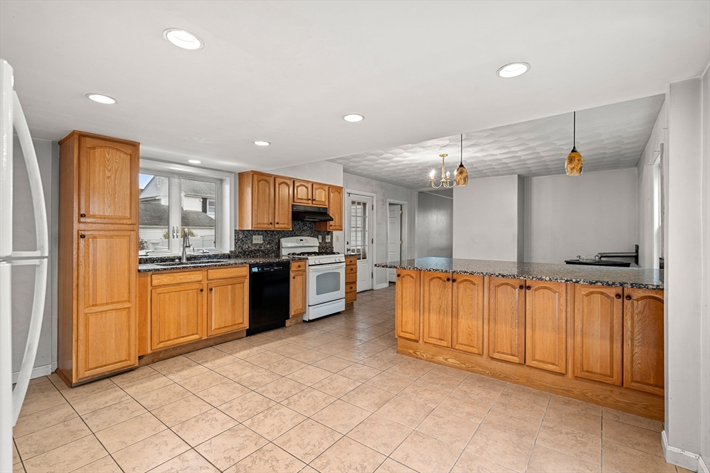 26 Elm Peabody, MA 01960 - Photo 15 of 41 a large kitchen with stainless steel appliances kitchen island granite countertop a refrigerator and a stove top oven