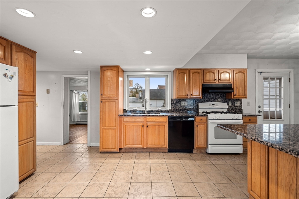 26 Elm Peabody, MA 01960 - Photo 19 of 41 a kitchen with stainless steel appliances granite countertop a refrigerator and a stove top oven