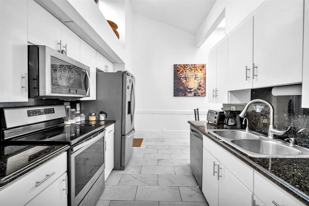 22710 Meridiana Drive Boca Raton, FL 33433 - Photo 10 of 39 a kitchen with stainless steel appliances a sink a stove and a refrigerator