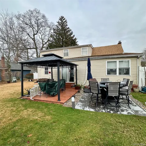 a view of a house with a backyard and sitting area