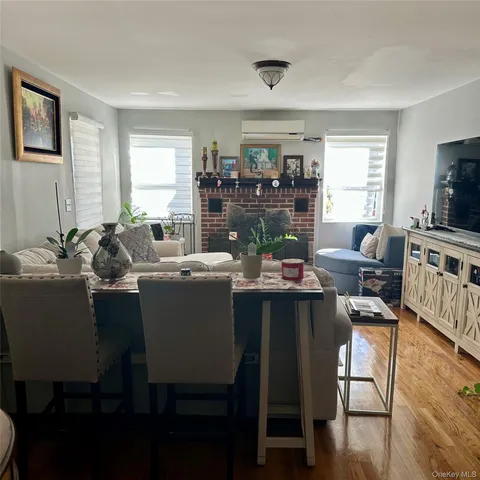 a dining room with wooden floor and large windows