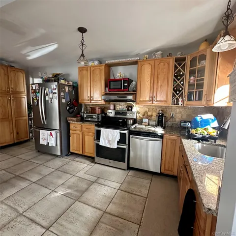 a kitchen with stainless steel appliances granite countertop a stove top oven a sink dishwasher and a refrigerator