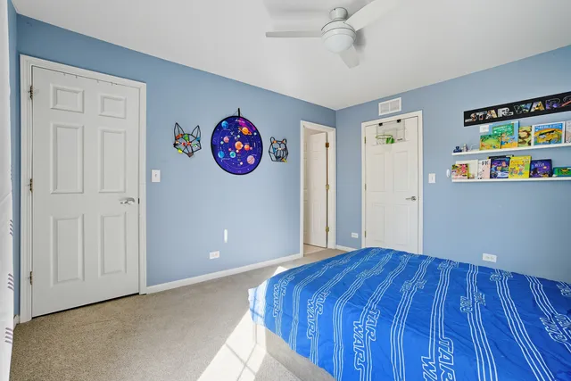a view of an empty room with bookshelf and a window