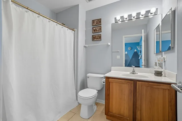 a bathroom with a granite countertop sink toilet and mirror