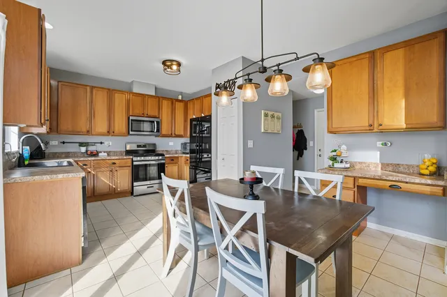 a kitchen with granite countertop a stove a sink a dining table and chairs