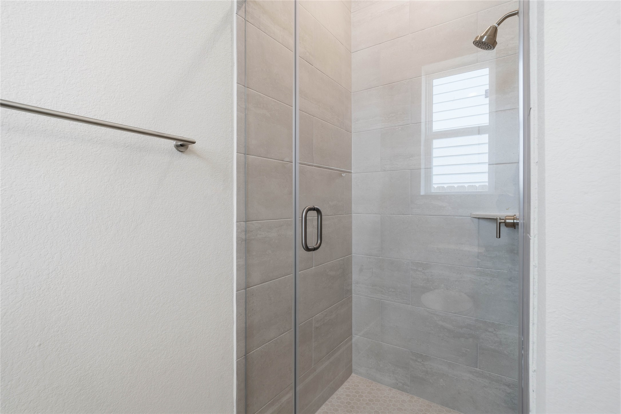 9123 Petroglyph Pt Court Porter, TX 77365 - Photo 10 of 43 This bright secondary bathroom features a sizable walk-in shower with tile surround, vanity, mirror, and sleek modern finishes.