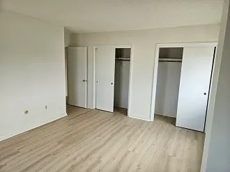 an empty room with wooden floor and window