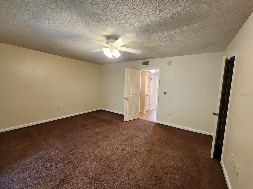 501 Southwest 75th Street, Unit A14 Gainesville, FL 32607 - Photo 43 of 56 an empty room with a ceiling fan and a view of a bathroom
