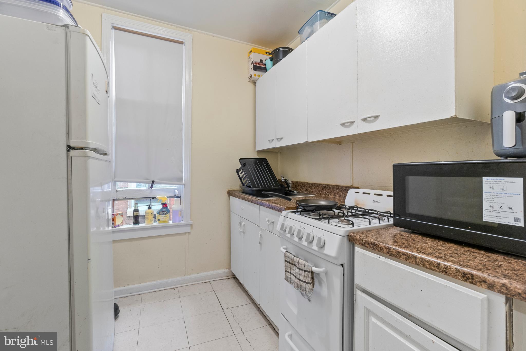 112 East 20th Street Baltimore, MD 21218 - Photo 14 of 23 a kitchen with appliances cabinets and a counter top space