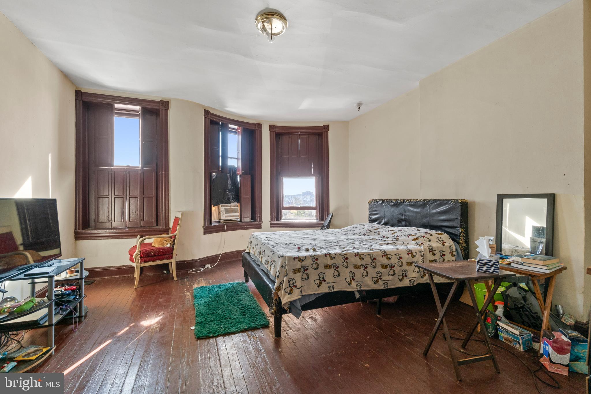 112 East 20th Street Baltimore, MD 21218 - Photo 2 of 23 a bedroom with a bed and large windows
