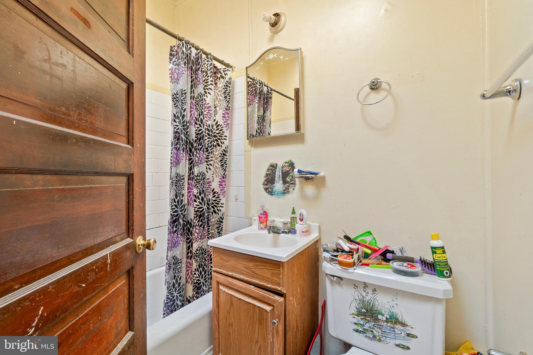112 East 20th Street Baltimore, MD 21218 - Photo 4 of 23 a bathroom with a sink mirror vanity and toilet