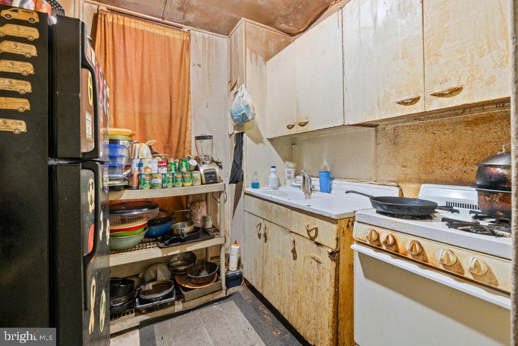 112 East 20th Street Baltimore, MD 21218 - Photo 7 of 23 a kitchen with stainless steel appliances granite countertop a stove a sink and a refrigerator