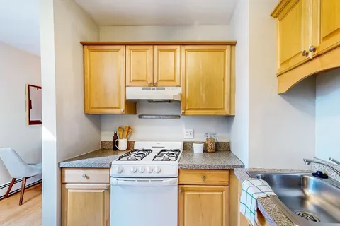a kitchen with stainless steel appliances granite countertop a sink stove and cabinets