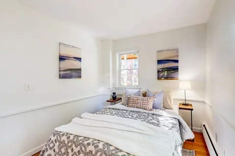a bedroom with a bed and a painting on the wall