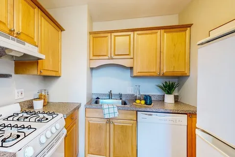a kitchen with stainless steel appliances granite countertop a sink a stove and a microwave