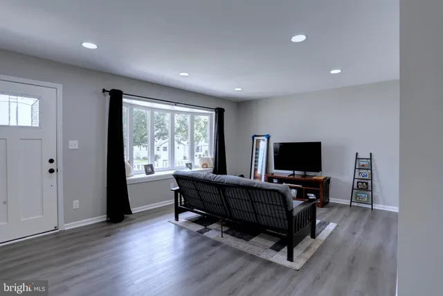 a living room with furniture flat screen tv and wooden floor