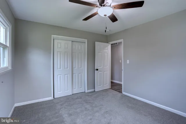an empty room with chandelier fan