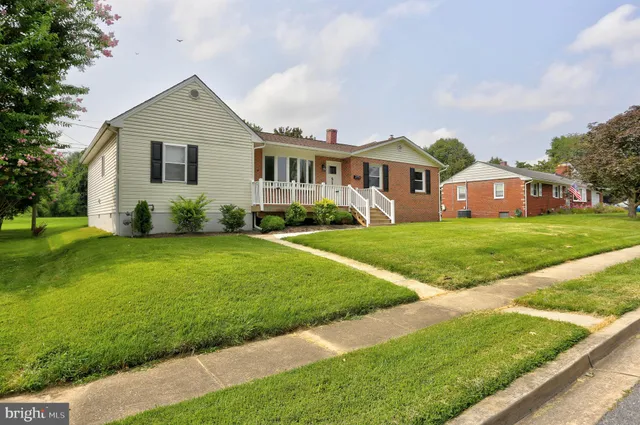 a front view of a house with a garden and trees