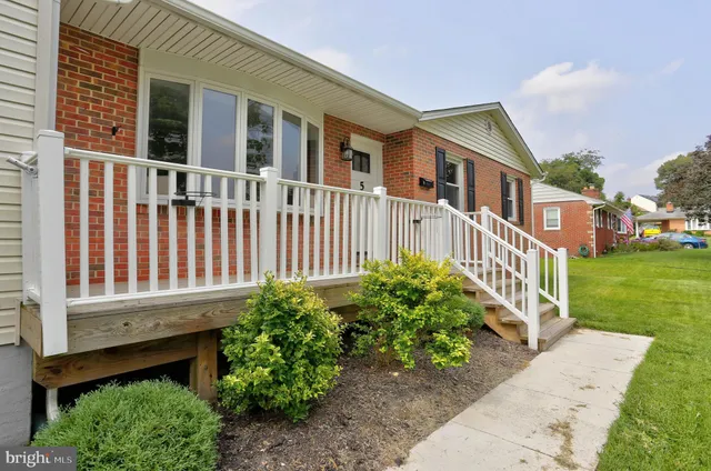 a view of a house with a small yard and a wooden fence