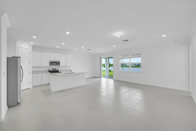 a view of kitchen with kitchen island stainless steel appliances refrigerator sink and stove