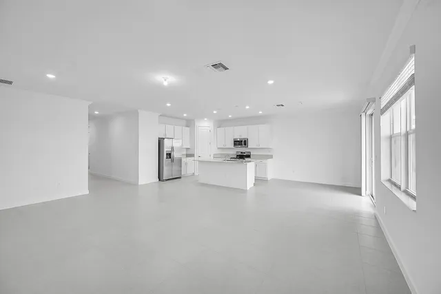 a view of kitchen with kitchen island and stainless steel appliances
