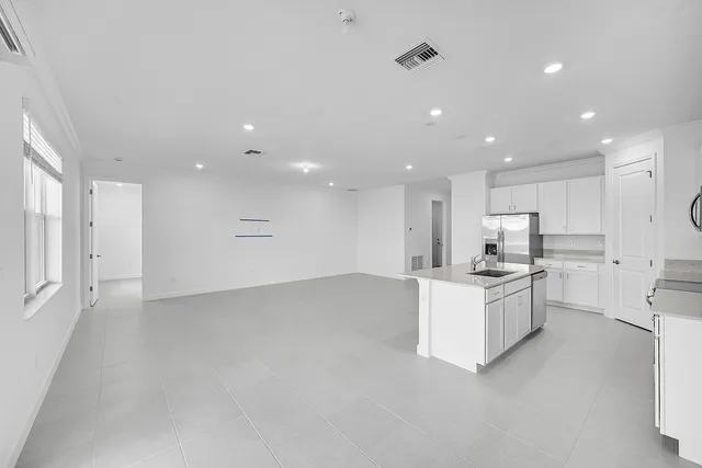 a open kitchen with white cabinets and white appliances