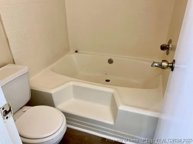 a white bath tub sitting next to a white toilet