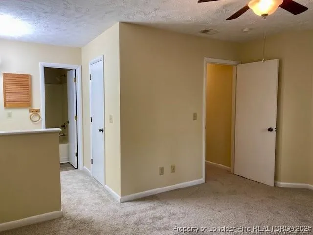 an empty room with closet and a chandelier fan